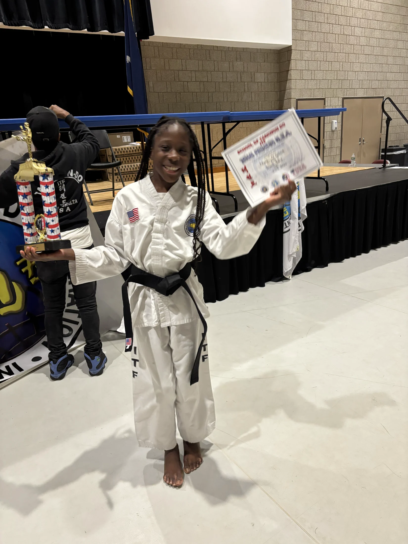 Avi holding her Taekwondo trophy and certificate